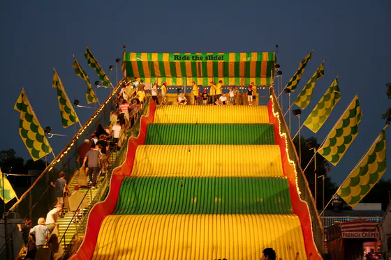 The Giant Slide lit up in yellow and green after dark