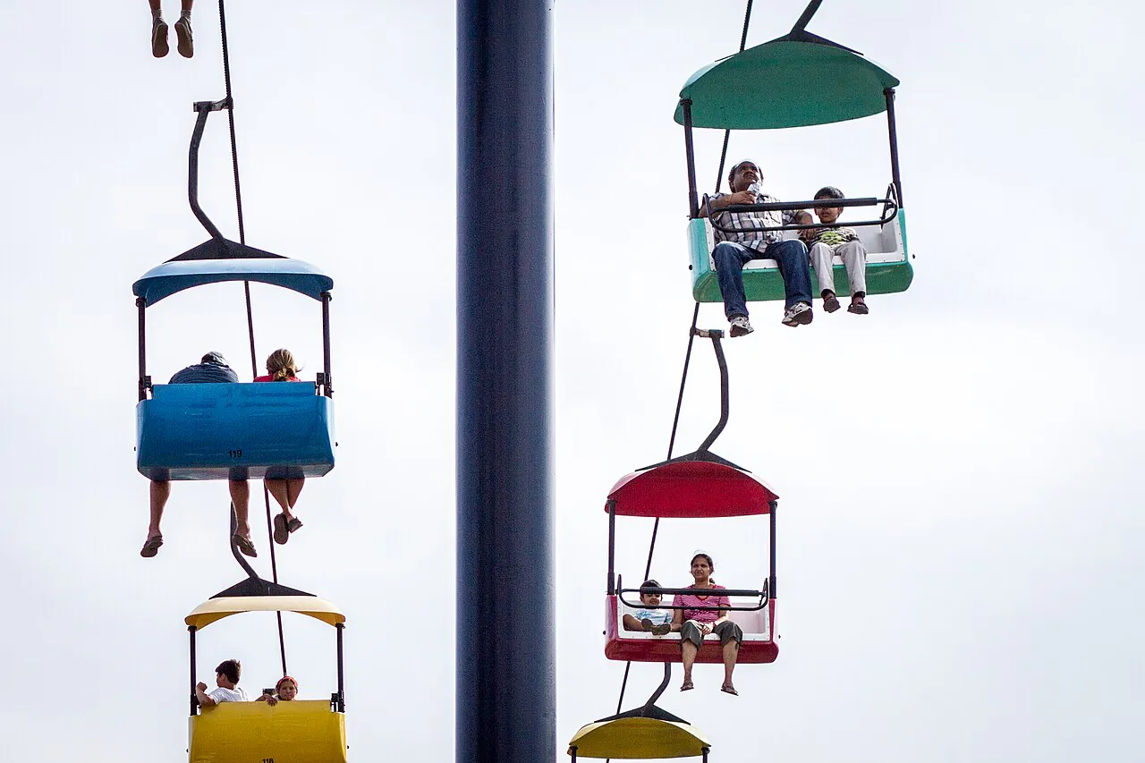 Sky Ride gondolas in yellow, blue, green and red carrying fairgoers high above the Minnesota State Fairgrounds